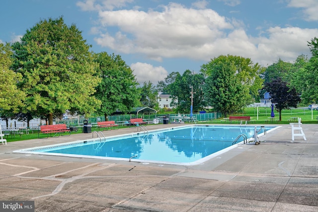 view of swimming pool with a patio area and a yard