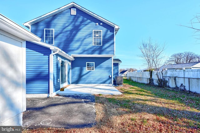 rear view of property featuring a patio area and a lawn