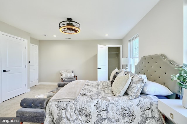 carpeted bedroom featuring a walk in closet and a closet