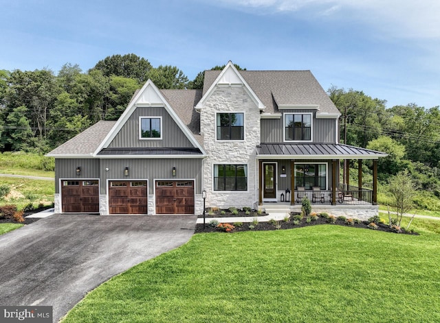 view of front facade featuring a garage, a front yard, and covered porch