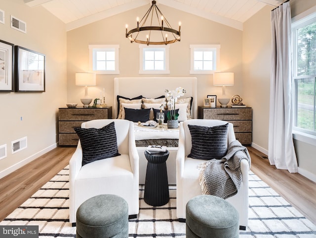 bedroom featuring lofted ceiling with beams, a notable chandelier, multiple windows, and light hardwood / wood-style floors