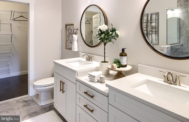 bathroom featuring dual vanity, toilet, and tile patterned flooring