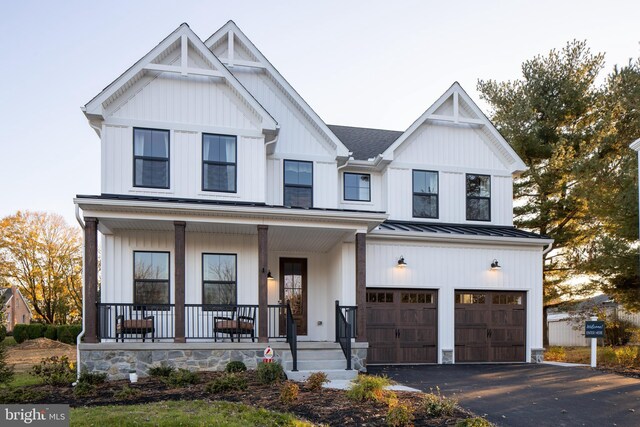 modern farmhouse with covered porch and a garage