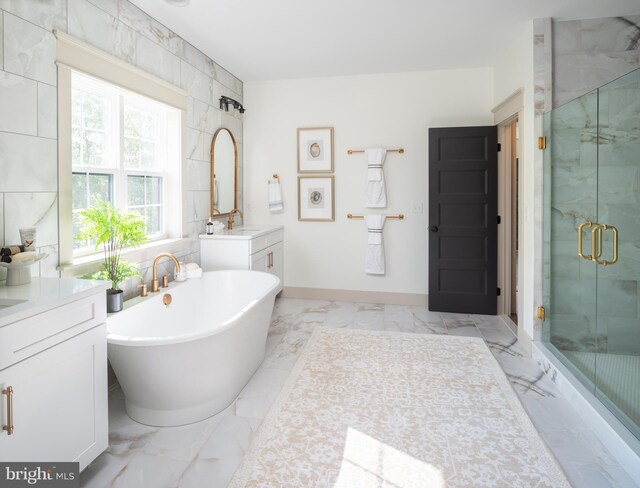 bathroom with vanity, shower with separate bathtub, and tile walls