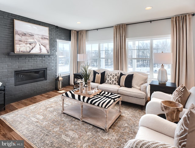 living area with a brick fireplace, wood finished floors, and recessed lighting