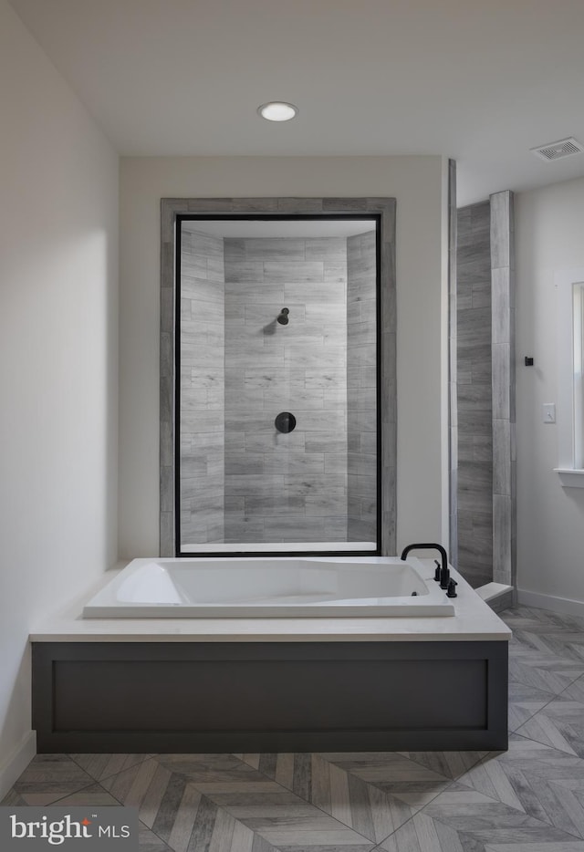 bathroom featuring visible vents, baseboards, and a bath