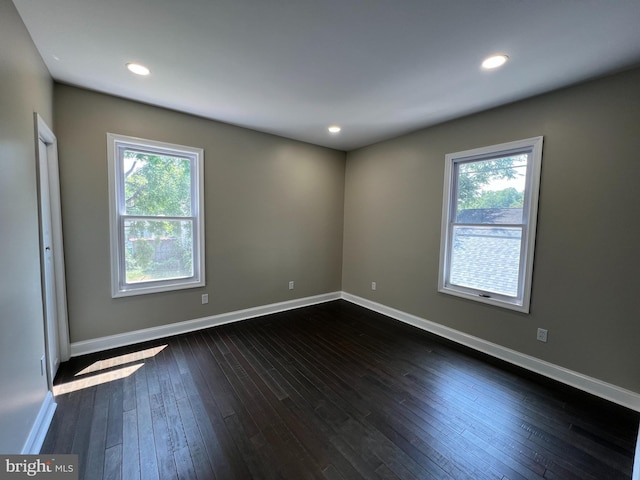 spare room with plenty of natural light and dark hardwood / wood-style floors