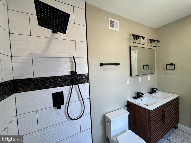 bathroom featuring a shower, vanity, and toilet