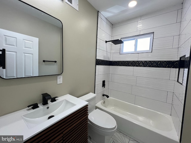 full bathroom featuring tile patterned flooring, tiled shower / bath combo, toilet, and vanity