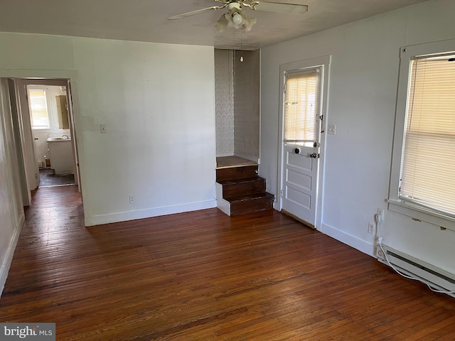 unfurnished room with a baseboard heating unit, ceiling fan, and dark hardwood / wood-style floors