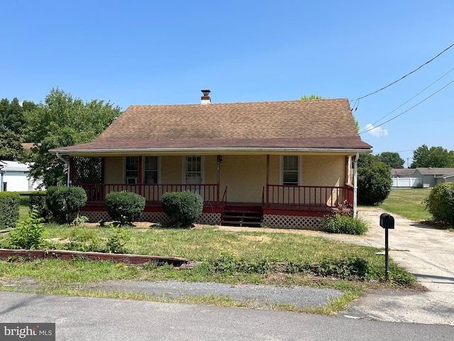 view of front of property featuring covered porch and a front lawn