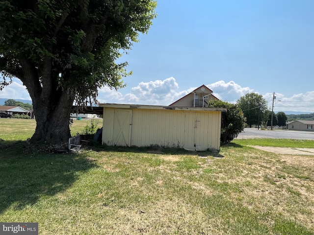 view of home's exterior with a yard and an outdoor structure