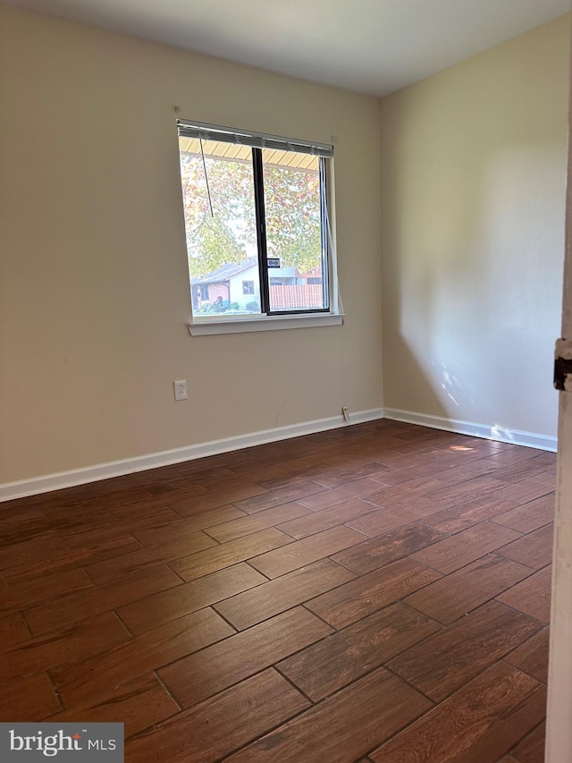 unfurnished room with dark hardwood / wood-style flooring