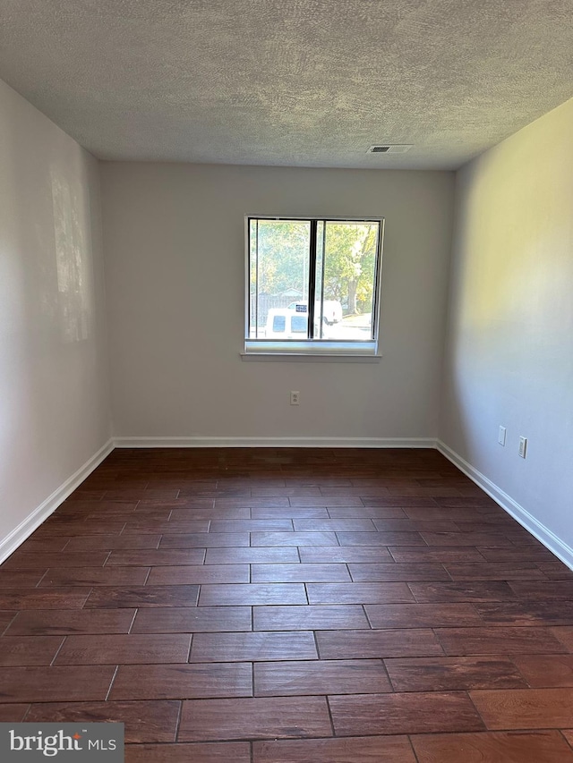 spare room with a textured ceiling