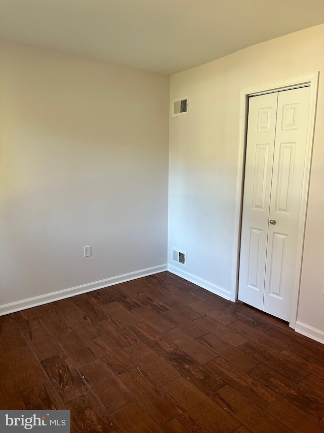 empty room with dark hardwood / wood-style flooring