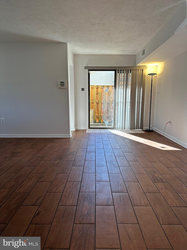 unfurnished room with a textured ceiling