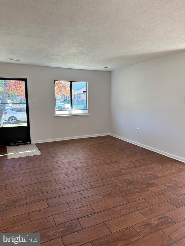 spare room with a textured ceiling and a healthy amount of sunlight