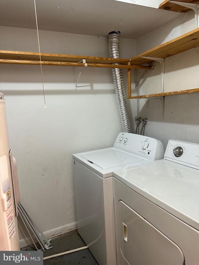 clothes washing area featuring water heater and washing machine and dryer