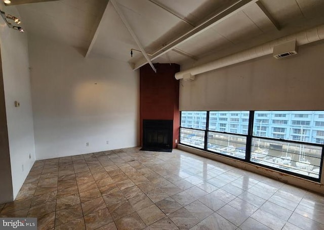 unfurnished living room featuring a towering ceiling and tile patterned floors