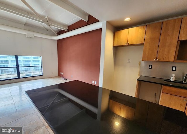 kitchen with sink and vaulted ceiling with beams