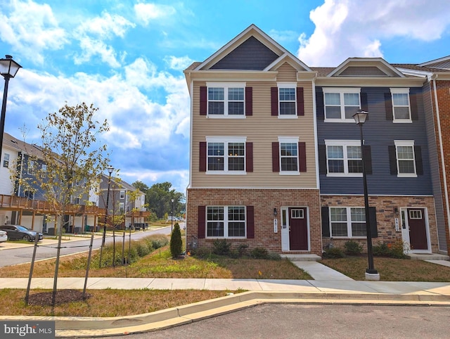view of property featuring a residential view and brick siding