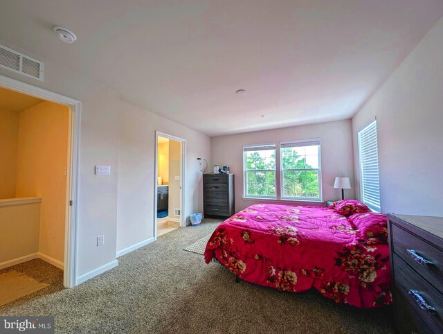 bedroom featuring ensuite bathroom and carpet flooring