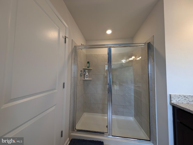 bathroom with vanity and a shower with shower door