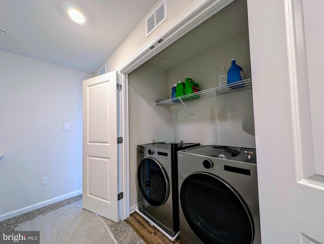 laundry area with washer and dryer and light hardwood / wood-style floors