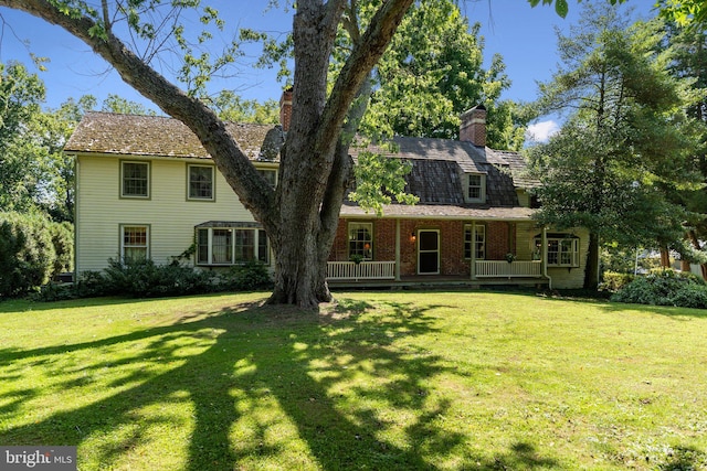 view of front of home with a wooden deck and a front lawn