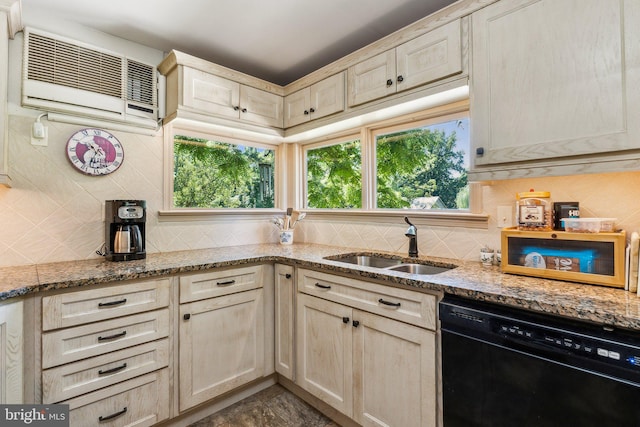 kitchen featuring sink, light stone counters, an AC wall unit, black dishwasher, and a wealth of natural light