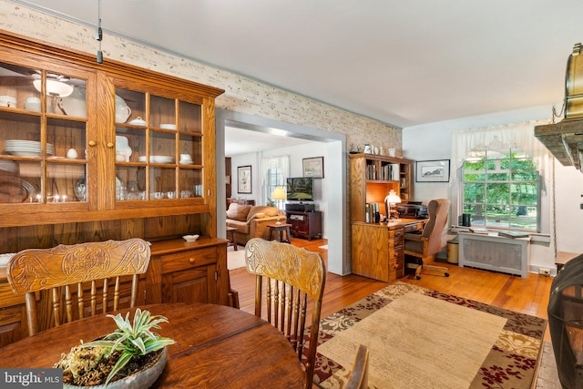 dining space with radiator and light hardwood / wood-style flooring