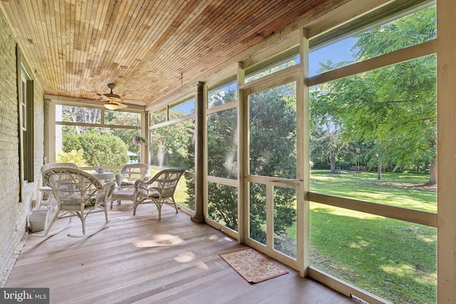 unfurnished sunroom featuring wooden ceiling and ceiling fan