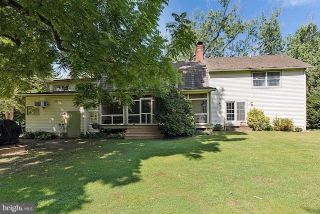 rear view of property with a yard, a sunroom, and a wall mounted AC