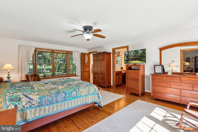 bedroom featuring ceiling fan, connected bathroom, and light wood-type flooring