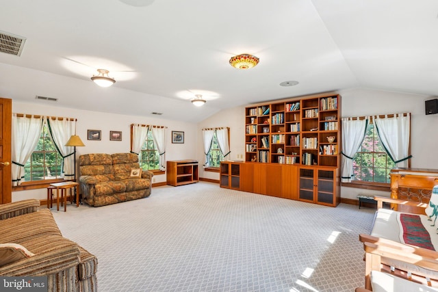 interior space with carpet, a healthy amount of sunlight, and lofted ceiling