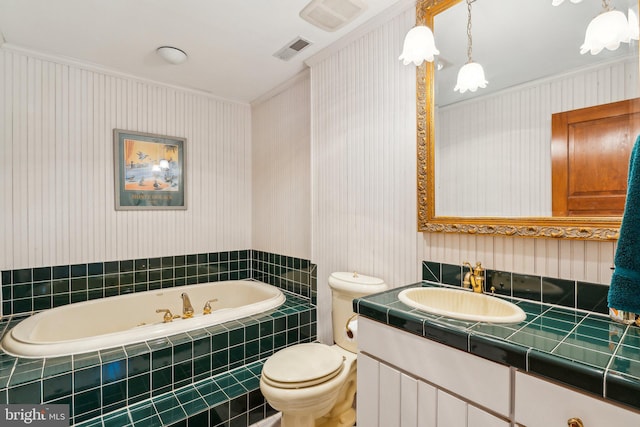 bathroom featuring crown molding, vanity, toilet, and a relaxing tiled tub