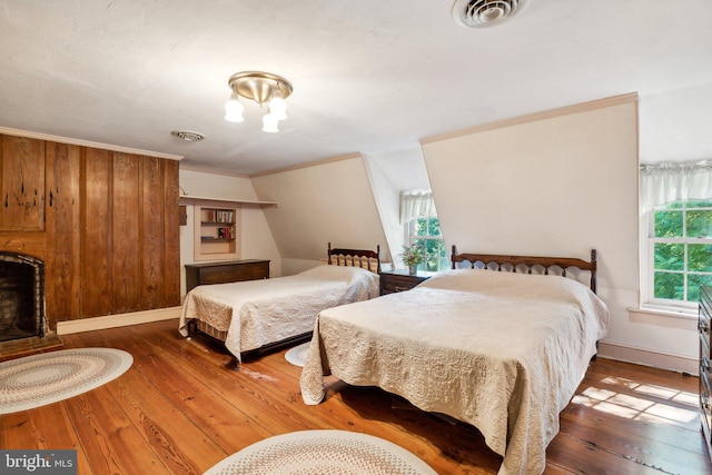 bedroom featuring multiple windows, crown molding, and hardwood / wood-style floors