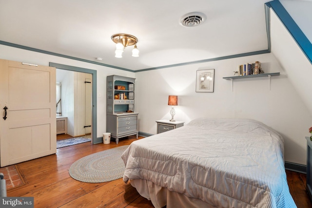 bedroom with crown molding and dark wood-type flooring