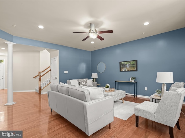 living room with ceiling fan, light hardwood / wood-style floors, and ornate columns