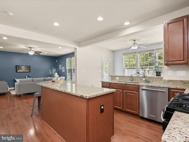 kitchen featuring a kitchen island, dishwasher, wood-type flooring, sink, and plenty of natural light