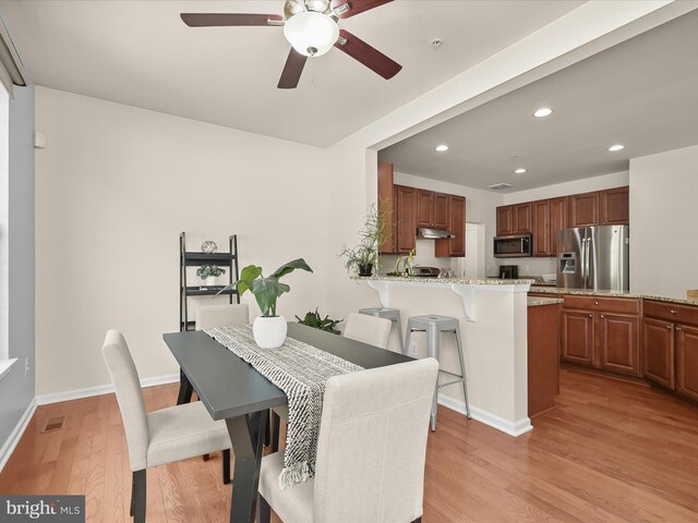 dining room with ceiling fan and light hardwood / wood-style floors