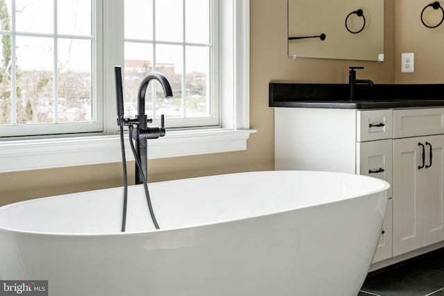 bathroom with vanity and a tub