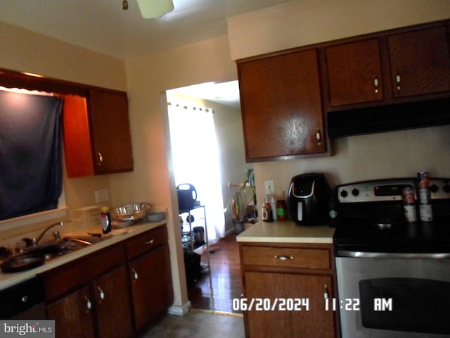 kitchen with electric range, sink, wood-type flooring, and extractor fan