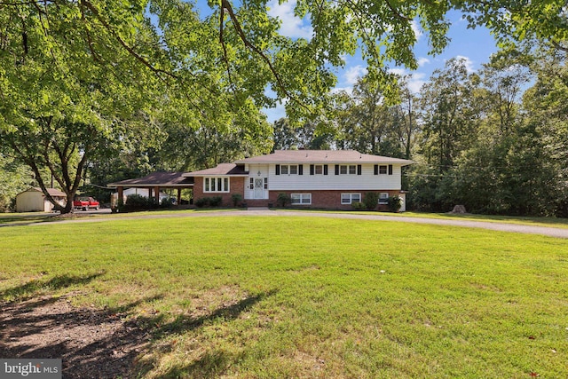 tri-level home featuring brick siding and a front yard