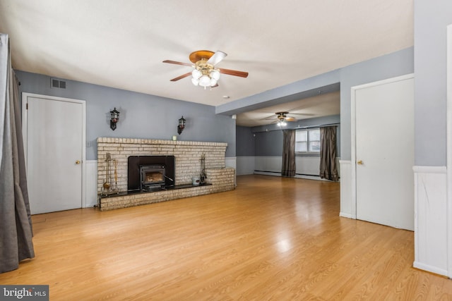 unfurnished living room with light wood-type flooring, visible vents, and a ceiling fan