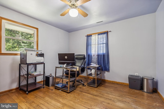 office area with a ceiling fan, visible vents, light wood-style flooring, and baseboards