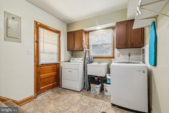 laundry area featuring washer and clothes dryer, cabinet space, a sink, electric panel, and baseboards