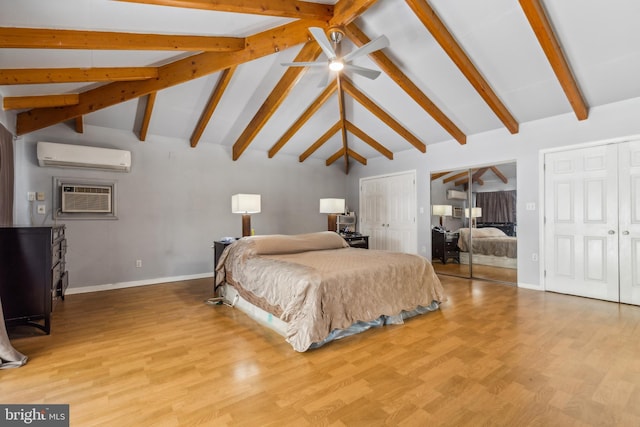 bedroom with light wood finished floors, baseboards, a wall unit AC, lofted ceiling with beams, and multiple closets