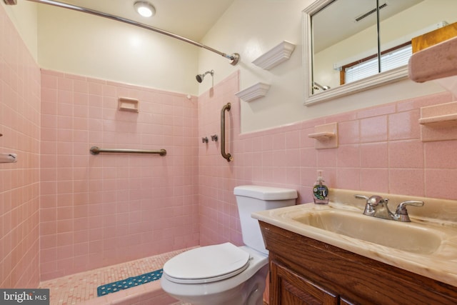 full bathroom featuring visible vents, toilet, vanity, a shower stall, and tile walls