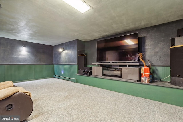 carpeted cinema room with baseboard heating and wainscoting